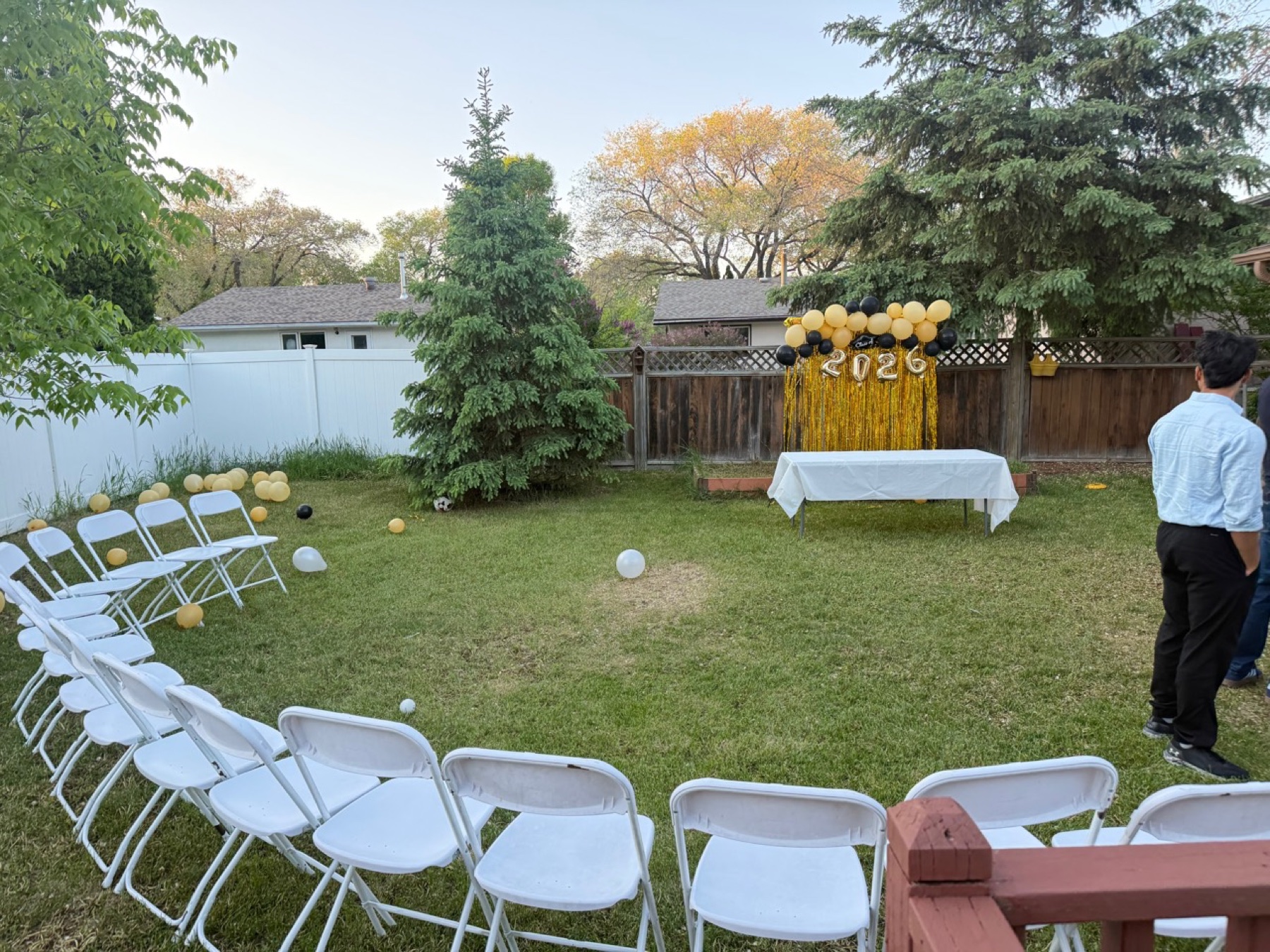 Winnipeg backyard event setup with chairs, table, balloons, and backdrop