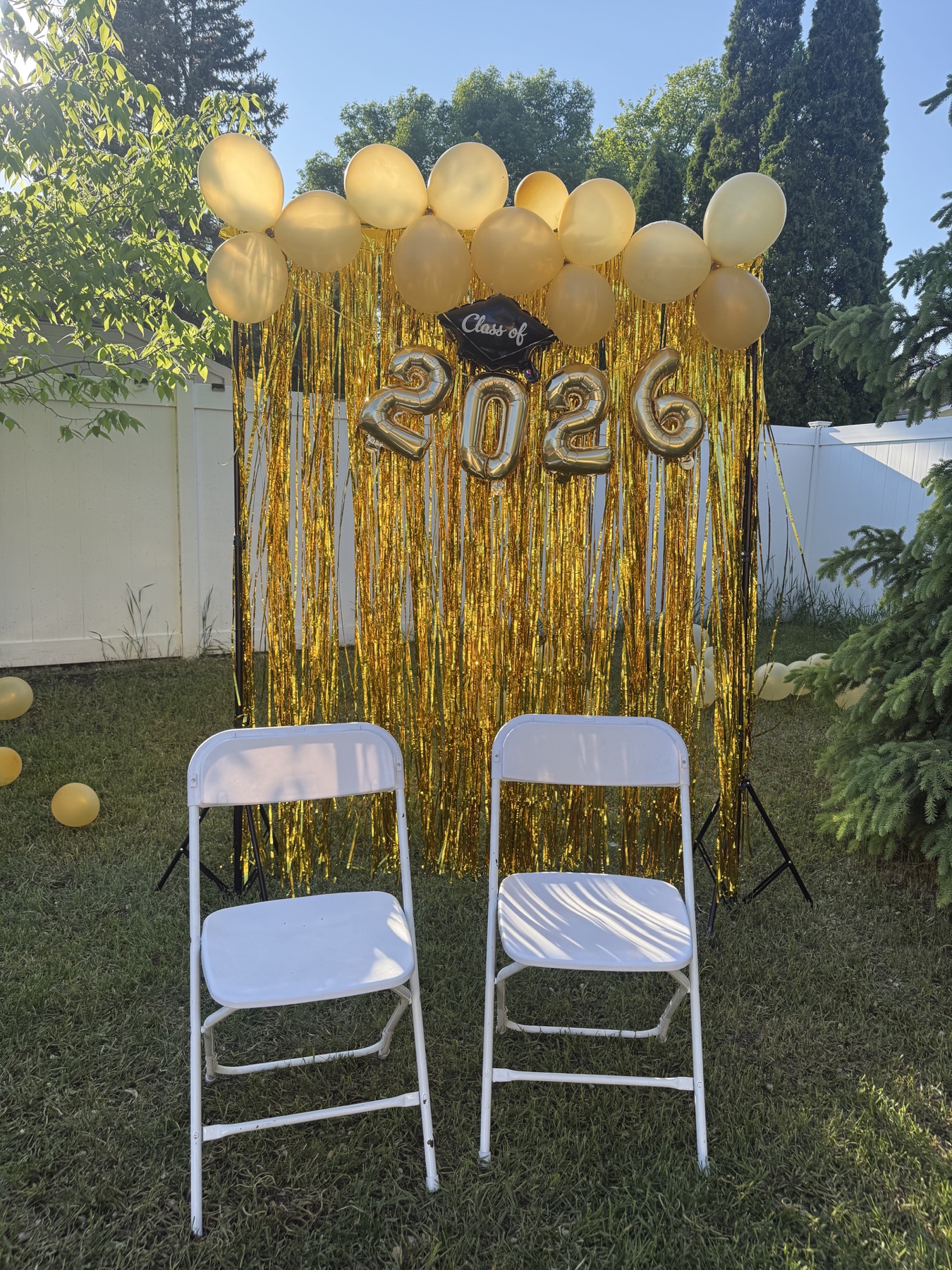 Graduation party photo backdrop with white chairs in Winnipeg
